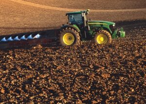 A tractor prepares a farm field for planting