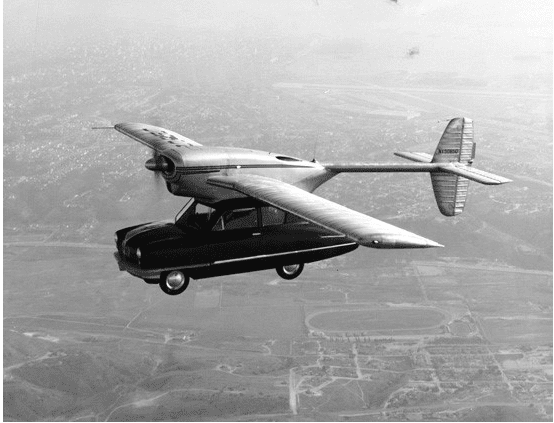 Not everyone saw the future of vehicles as autonomous. One inventor's vision for the future saw cars take flight. Pictured is a prototype flying car, a Corvair Model 118 car with wings attached to its roof. The photo is taken from slightly above the prototype car from another plane, with the countryside below in the distant background